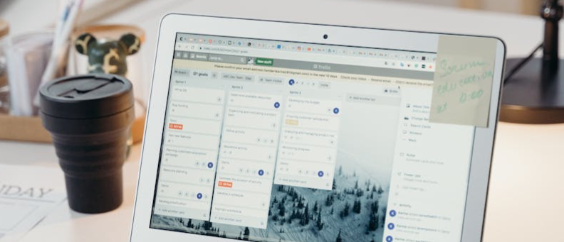 a laptop in a modern office setting with notes and task management software visible on the screen.