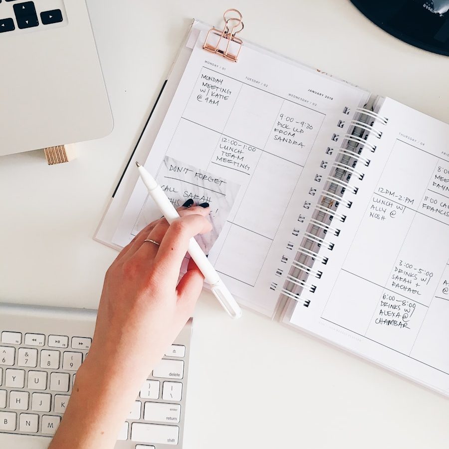 Photo by Marissa Grootes person holding notepad and pen flat lay photography